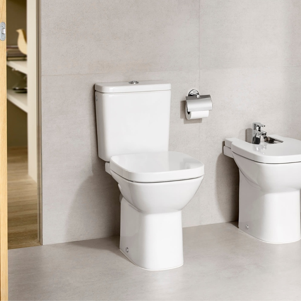 Lifestyle image of the Roca Debba Square Rimless Close Coupled Open Back Toilet installed in a bathroom, next to a Roca Bidet.